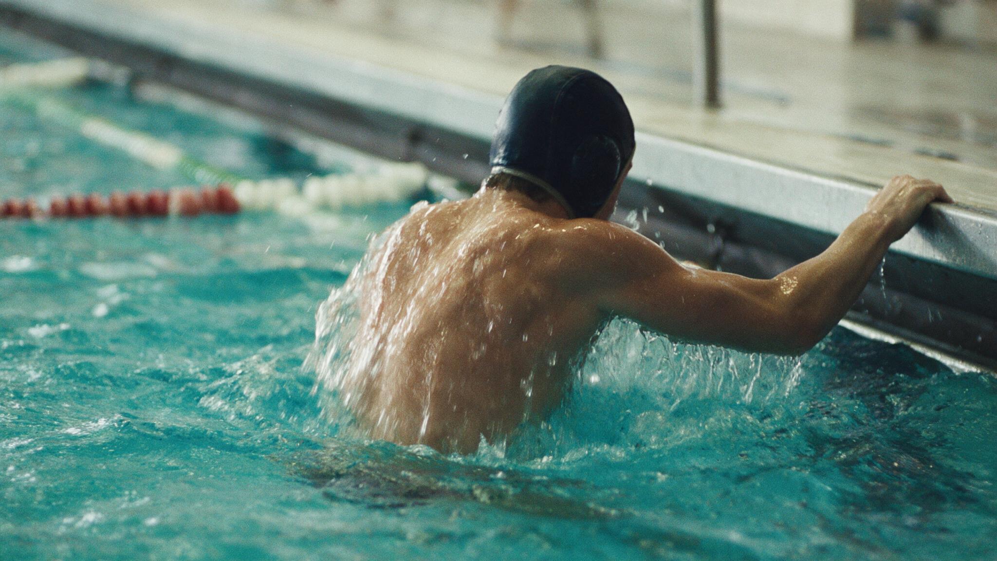 Joueur de water-polo au bord du bassin à l'entraînement, tenue personnalisée en sublimation